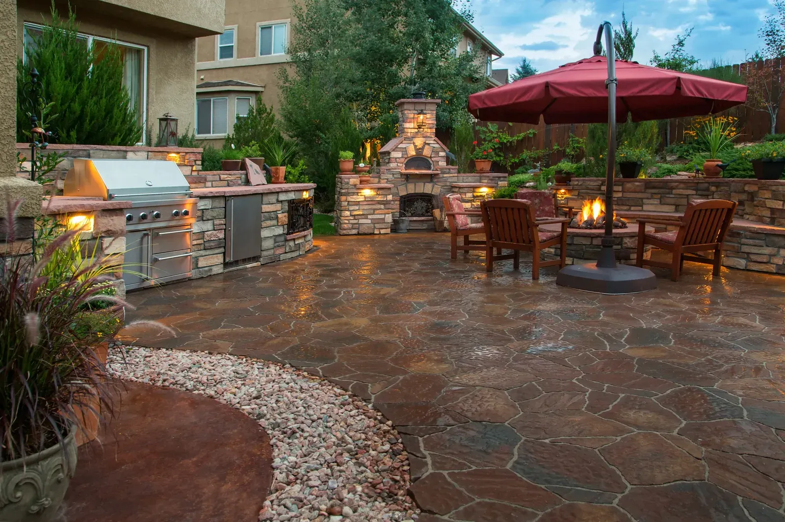 Stone patio with an outdoor fireplace and seating